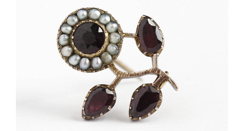 Here, a brooch circa 1830 from Mae Jean Vintage. The dainty floral pin features four purplish-red garnets with closed backs and seed pearls set in 10-karat rose gold. 